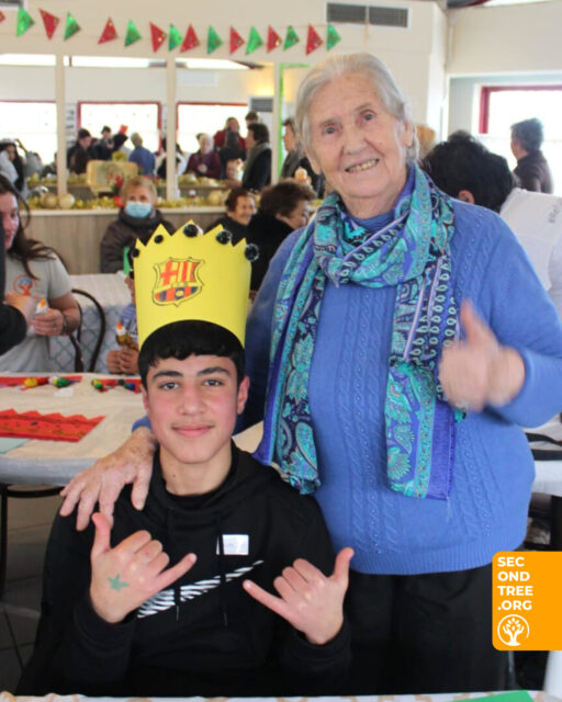 They say integration has no age limit. 🫂⁠
⁠
If you've never heard that expression before, it's because we just made it up – inspired by an invitation from the elderly community of our local Greek village, Loggades! 💌⁠
⁠
Along with kids from our youth programmes in Katsikas & Agia Eleni refugee camps, we joined them to make arts & crafts, cut cake & welcome in the New Year together – an authentic Greek affair.⁠
⁠
Vasilis, the stern-faced bus driver, smiled as kids bounced behind their teachers in single file, towards a group of beaming Yiayias (grannies) welcoming us to their space. 🚌⁠
⁠
Sitting down in little groups, we welcomed each elderly arrival with a high-pitched "KALI CHRONIA" (happy new year)! The Grandmas replied by stuffing us full of cake & fussing over us all.⁠
⁠
After a round of speeches, a red-faced Barzan – nudged on by his pals – gingerly rose from his seat, turned to his aged audience & announced, "Efcharistó!" (thank you!) to roaring applause.⁠
⁠
11-year-old Havva then teamed up with 80-year-old Despoina to craft crowns & decorations together. 👑
⁠
For a few hours, everyone had someone to teach & someone to learn from. Two isolated communities coming together – kids who rarely leave the refugee camp, & elders with traditions to pass on & love to spare.⁠
⁠
Donate today to help us continue replacing isolation with #connection. Link in bio ☝️⁠

A special Efkharistó (thank you) to Professor Markoula and the Municipality of Ioannina for introducing us to our new friends!
⁠
#WeAreSecondTree #RefugeesArePeople #YouthProgramme #Yiayia #RefugeeCamp #Community #FightIsolation